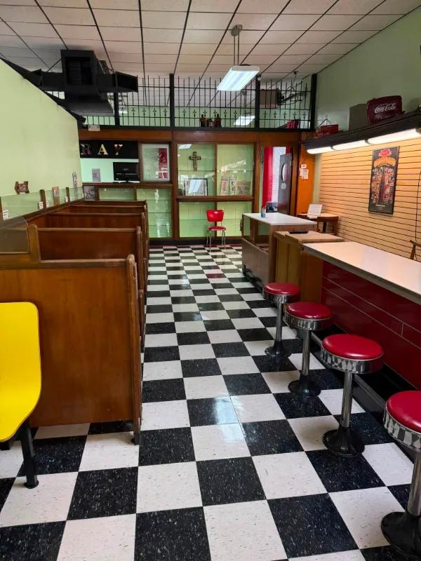 Booths and black-and-white checkerboard floor inside the shop